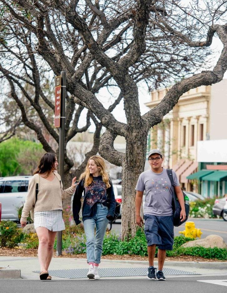 Students walk on the sidewalk in downtown Claremont